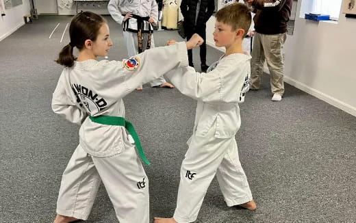 a couple of children in karate uniforms