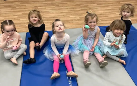 a group of children sitting on a mat
