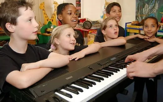 a group of kids playing a piano