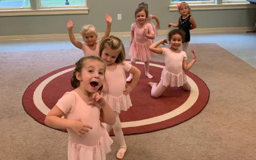 a group of girls in dresses dancing