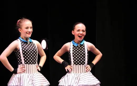 two girls wearing dresses and posing for a picture