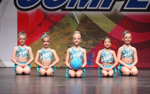 a group of girls in blue dresses