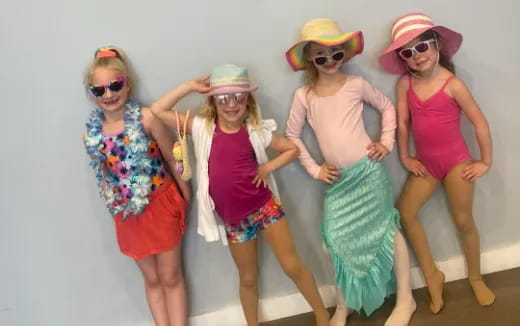a group of women wearing hats and posing for a photo