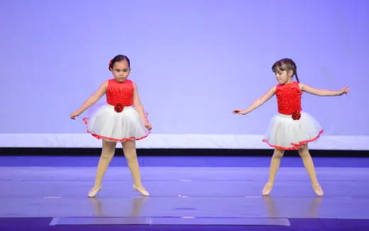 two girls wearing dresses and dancing
