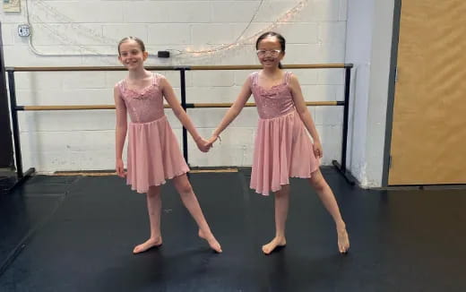 two girls wearing dresses and dancing