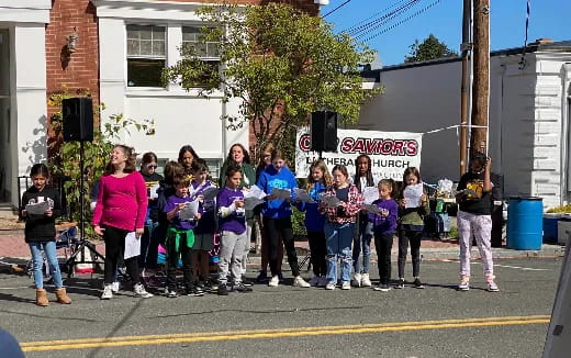 a group of people standing on the side of a street