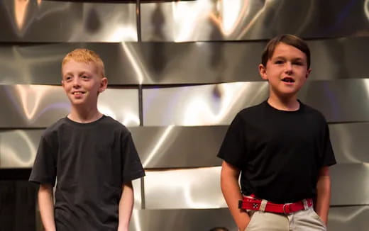 two men standing in front of a white wall