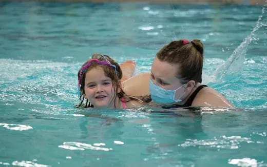 a person and a girl swimming in the water