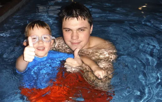 a person and a boy in a pool