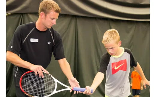 a man and a boy holding tennis rackets