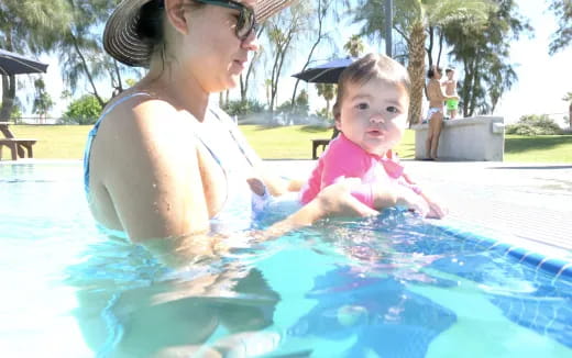 a person and a baby in a pool