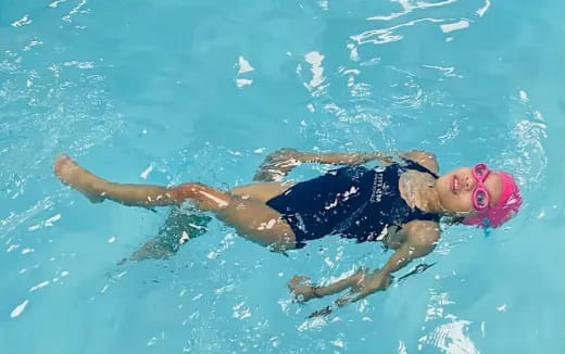 a couple people swimming in a pool