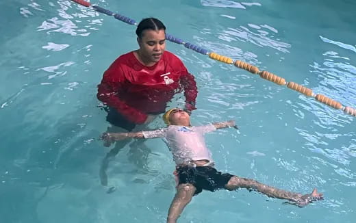 a man holding a baby in a pool