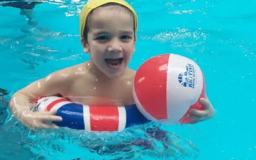 a boy in a pool with a ball