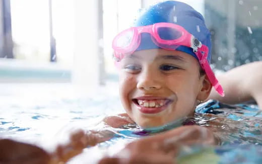 a girl in a pool wearing goggles