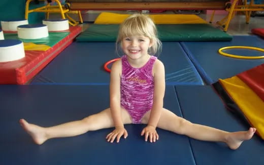 a girl sitting on a mat