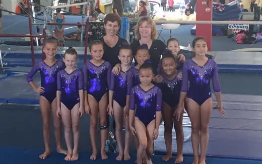 a group of girls in leotards posing for a photo