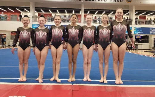 a group of women in leotards posing for a photo