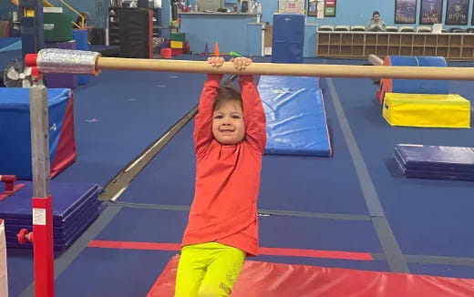 a child in a red hoodie holding onto a bar