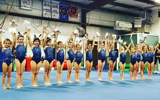 a group of women in blue leotards standing on a stage