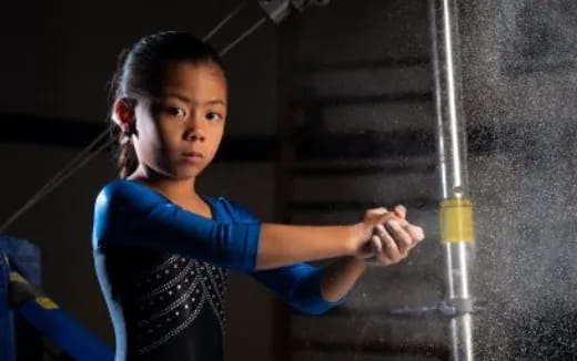 a young girl with her hand on a metal bar