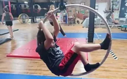 a person doing a back bend in a gym