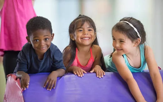 a group of children sitting on a bed