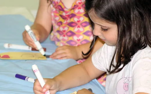a young girl writing on a blue paper