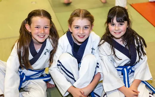 a group of girls in karate uniforms