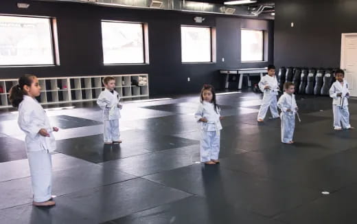 a group of children in white karate uniforms