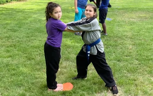 a couple of kids playing in the grass