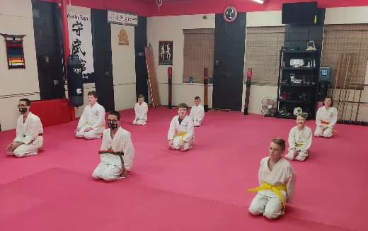 a group of people in white robes sitting on the floor