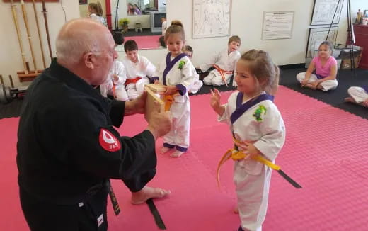a person and a girl in karate uniforms