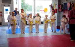 a group of children in yellow karate uniforms