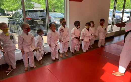 a group of children in white karate uniforms