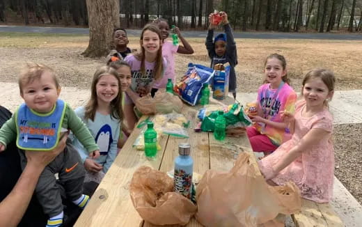 a group of children sitting at a picnic table