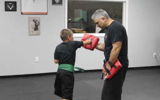a man and a child wearing boxing gloves