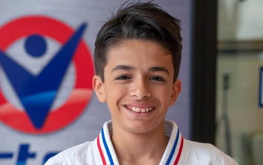a boy smiling with a flag behind him