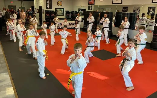 children in karate uniforms performing