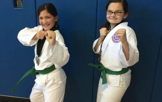 a couple of girls in karate uniforms