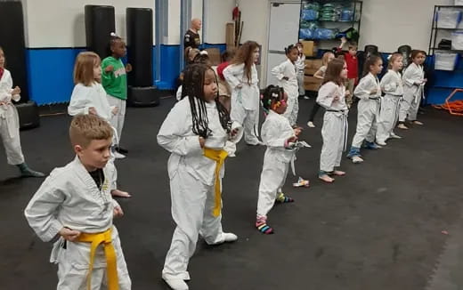 a group of children in white karate uniforms