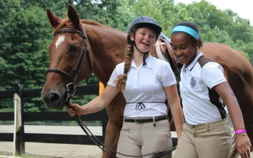 a couple of people stand near a horse