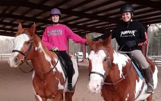 a couple of women riding horses