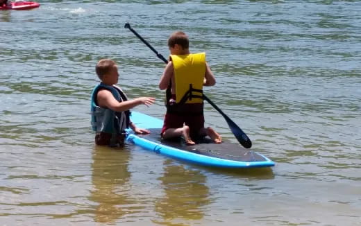 two boys on a paddle board