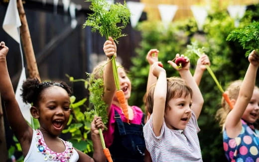 a group of children holding fruits