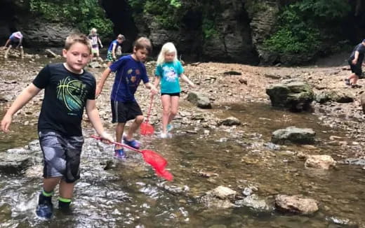 a group of kids playing in a river