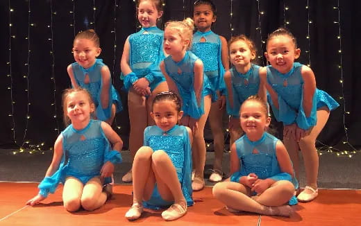 a group of girls in blue dresses