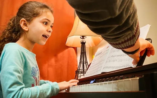 a person and a child playing piano