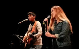 a man and woman singing into microphones