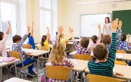 a group of children raising their hands